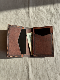 Hidden House Co. handcrafted brown leather bifold card wallet with saddle stitching and interior card slots.