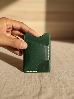 Hidden House Co. forest green minimalist leather card holder wallet with hand-stitched details held in a hand.