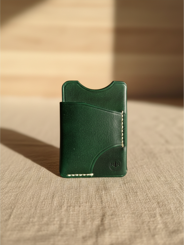 Hidden House Co. minimalist forest green leather card holder wallet with hand-stitched details on a neutral surface.