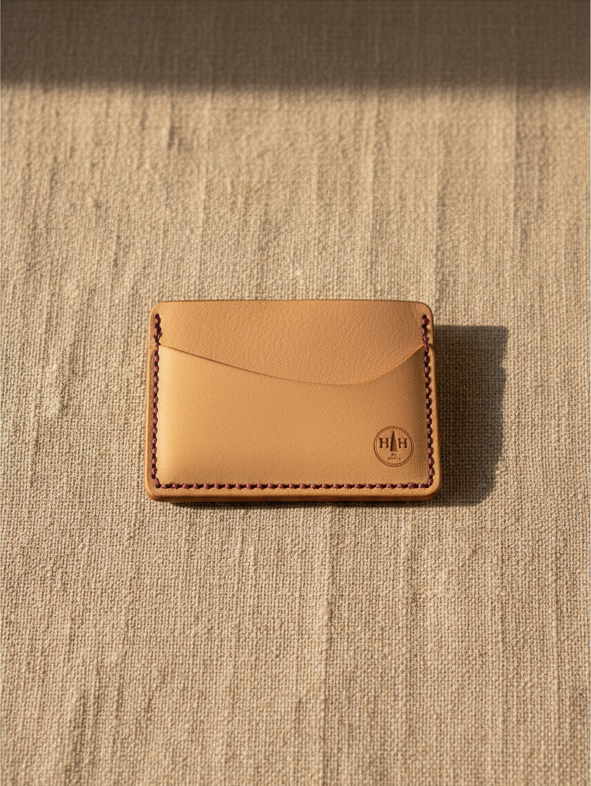 Hidden House Co. minimalist vegetable-tanned leather card holder with contrasting stitching and embossed logo.
