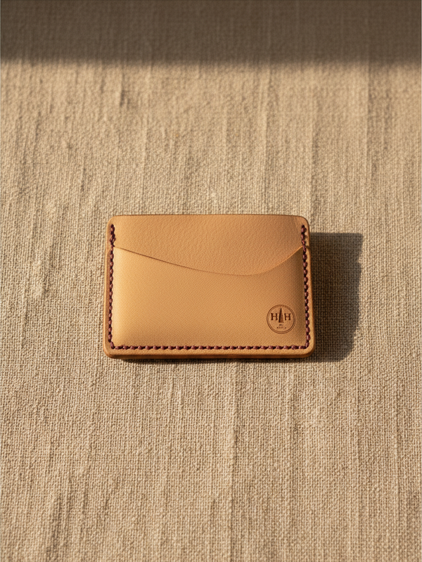 Hidden House Co. minimalist vegetable-tanned leather card holder with contrasting stitching and embossed logo.