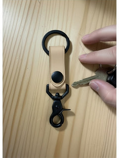 Hidden House Co. light tan vegetable-tanned leather keychain with matte black metal hardware and snap-button closure.
