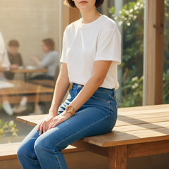 Hidden House Co. tan vegetable-tanned leather ring bracelet with a brass ring detail worn by a woman in a white tee.