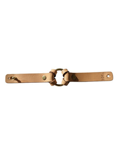 Hidden House Co. natural tan vegetable-tanned leather bracelet with a solid brass ring and adjustable stud closure.